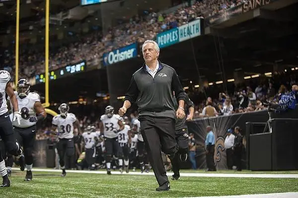 Dr. Sokoloff jogs onto a football field. The crowd is visible in the background.